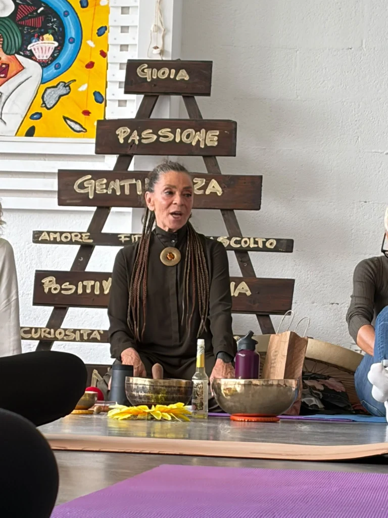 Campane tibetane sul pavimento, davanti a una persona seduta.